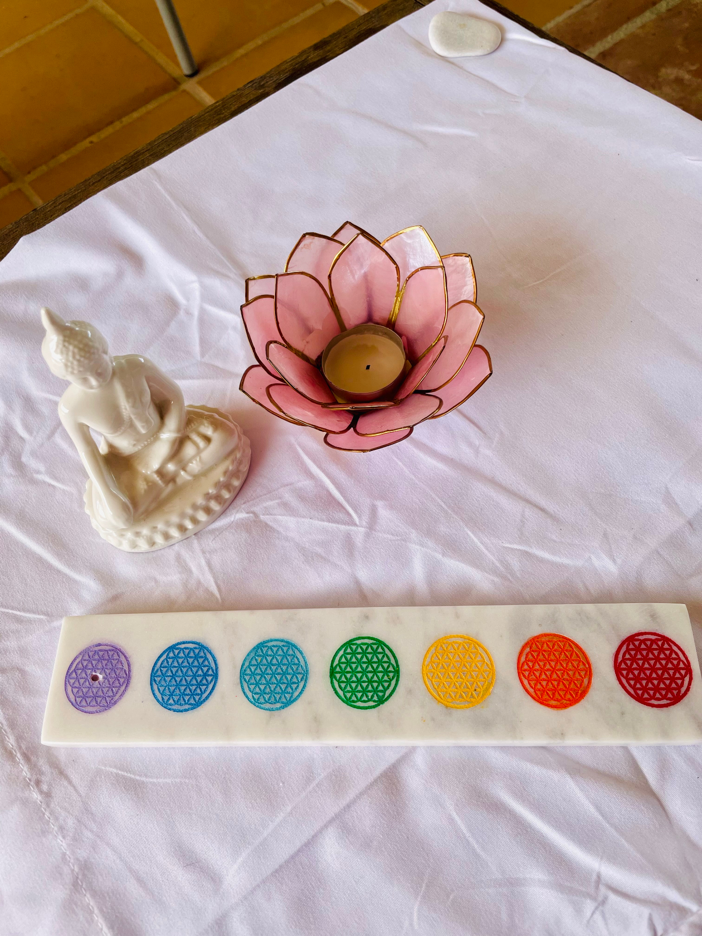 Small altar with a lotus candle holder, Buddha figure and chakra incense tray