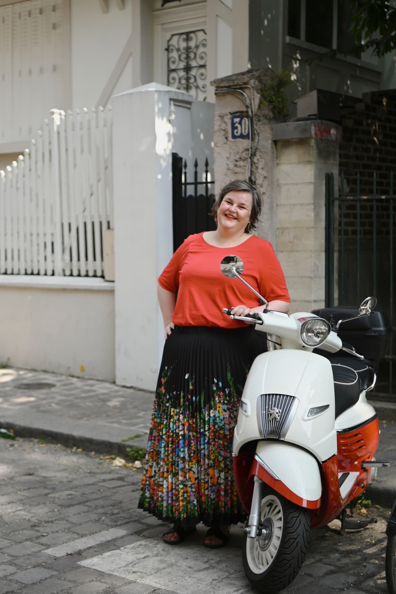 Sanne Frandsen standing beside a scooter on a Paris street