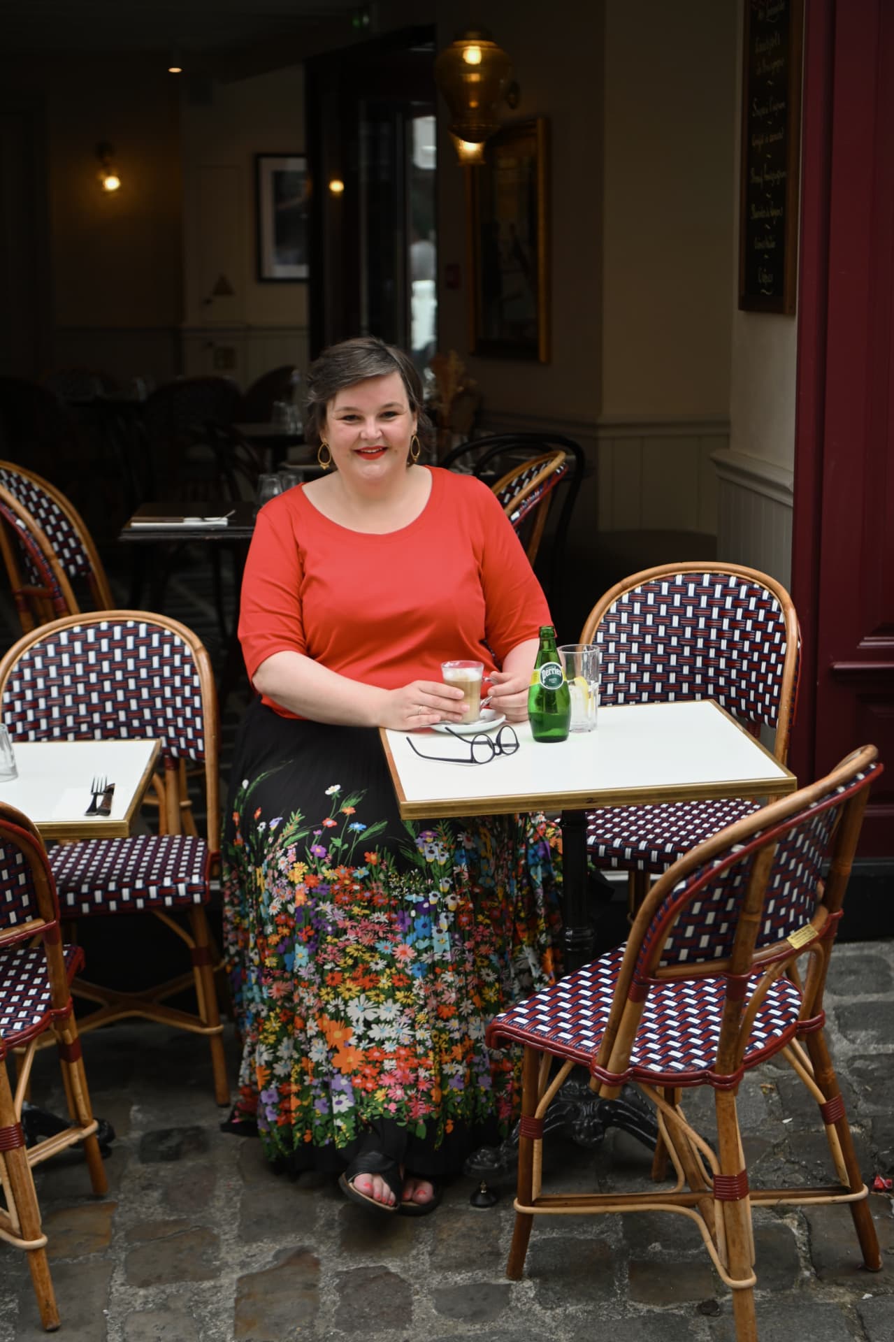 Sanne Frandsen sitting at a Parisian café table with a coffee