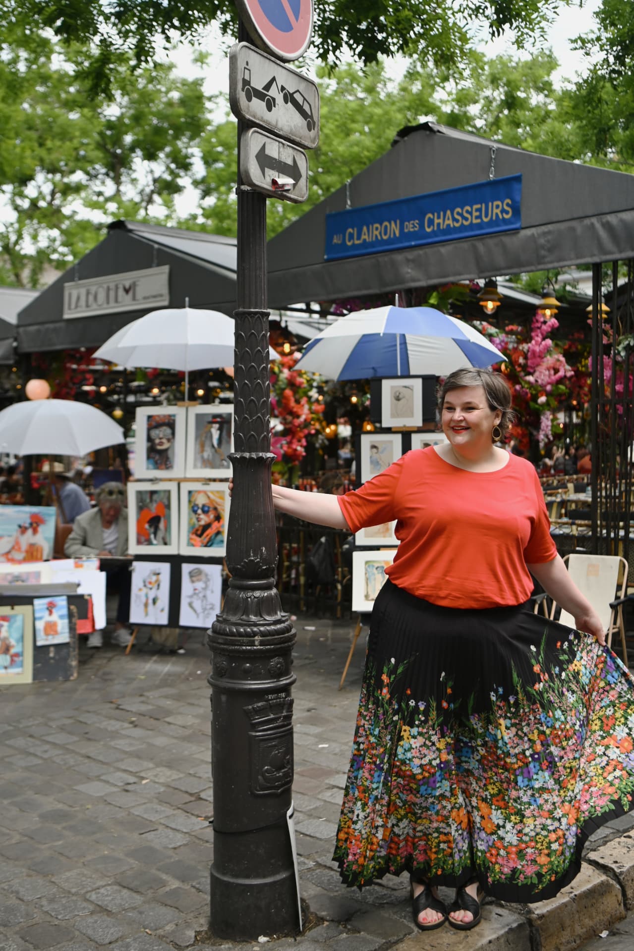 Sanne Frandsen smiling among artists' stalls in Montmartre, Paris